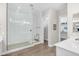 Bathroom featuring a walk-in shower with glass doors, white tiled walls, and wood look tile floors at 3466 E Hazeltine Way, Queen Creek, AZ 85142