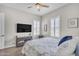 Cozy bedroom featuring a ceiling fan, tv, and white plantation shutters for natural light at 3466 E Hazeltine Way, Queen Creek, AZ 85142
