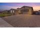 Charming home exterior with a paved driveway, manicured lawn, and beautiful desert landscaping at sunset at 3466 E Hazeltine Way, Queen Creek, AZ 85142