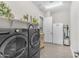 Bright laundry room with modern washer and dryer, wood look tile floors, and a white refrigerator at 3466 E Hazeltine Way, Queen Creek, AZ 85142