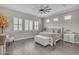 This bright main bedroom features plantation shutters, wood look tile, a fan, and a stylish neutral color scheme at 3466 E Hazeltine Way, Queen Creek, AZ 85142