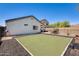 Backyard featuring a modern artificial turf lawn, and a view of the perimeter fence and the neighboring house at 11822 W Softwind Dr, Sun City, AZ 85373
