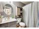 Cozy bathroom featuring a round mirror above the sink, a sliding barn door cabinet, and a shower with curtain at 11822 W Softwind Dr, Sun City, AZ 85373