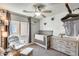 Charming Bedroom with a rocking chair, crib, dresser, ceiling fan and natural light at 11822 W Softwind Dr, Sun City, AZ 85373