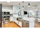 Modern kitchen featuring a spacious island with a stainless steel sink and appliances, and white cabinets at 11822 W Softwind Dr, Sun City, AZ 85373