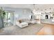 Open-concept living room features a large grey sectional sofa, plush carpet, recessed lighting, and sliding glass doors at 11822 W Softwind Dr, Sun City, AZ 85373