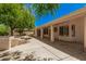 A covered patio overlooks the stone retaining wall and mature landscaping in the backyard at 15460 W Amelia Dr, Goodyear, AZ 85395