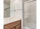 Bathroom with a white sink vanity, framed mirror and a shower over tub with glass doors at 15460 W Amelia Dr, Goodyear, AZ 85395