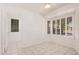 Well-lit bedroom with tile flooring, ample natural light from a window with plantation shutters, and a walk-in closet at 15460 W Amelia Dr, Goodyear, AZ 85395