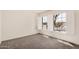 Bright bedroom featuring neutral paint, carpet, and shuttered windows overlooking the neighborhood at 15460 W Amelia Dr, Goodyear, AZ 85395