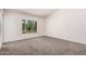 A spacious bedroom features light gray carpet, white walls and shutters at 15460 W Amelia Dr, Goodyear, AZ 85395