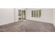 A view of a spacious bedroom featuring gray carpet and sliding glass doors at 15460 W Amelia Dr, Goodyear, AZ 85395