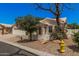 Cozy single-story residence featuring desert landscaping with mature tree and a yellow fire hydrant at 15460 W Amelia Dr, Goodyear, AZ 85395