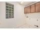 Functional laundry room with cabinet storage, tile floors and lots of natural light at 15460 W Amelia Dr, Goodyear, AZ 85395