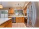 Well-lit kitchen with stainless steel refrigerator, tile floors, and wooden cabinets at 16642 N 35Th Way, Phoenix, AZ 85032