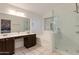 Ensuite main bathroom with double sink vanity, soaking tub, glass shower, and neutral tile at 16642 N 35Th Way, Phoenix, AZ 85032