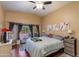 Bright main bedroom featuring a bay window with seating, ceiling fan, and tasteful wall decor at 16642 N 35Th Way, Phoenix, AZ 85032