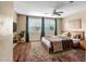 Cozy bedroom featuring hardwood floors, a ceiling fan, and large windows with stylish shutters at 3054 W Eagle Claw Dr, Phoenix, AZ 85086