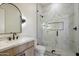 Bathroom featuring a unique mirror, marble tiled shower, and a marble countertop sink at 3323 N 81St St, Mesa, AZ 85207