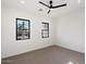 Spacious bedroom with plush carpet, black trim windows, and a ceiling fan at 3323 N 81St St, Mesa, AZ 85207