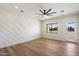 Bright, minimalist bedroom features a decorative accent wall, wood floors, ceiling fan, and exterior views at 3323 N 81St St, Mesa, AZ 85207