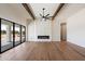 Spacious living room boasts wooden floors, beam ceiling, modern fireplace, and sliding glass doors at 3323 N 81St St, Mesa, AZ 85207