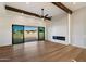 Modern living room with fireplace, open glass doors, and wood-beamed ceiling at 3323 N 81St St, Mesa, AZ 85207