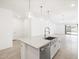 Modern kitchen island features granite countertops, stainless steel sink, and elegant pendant lighting at 4151 W Lisa Ln, San Tan Valley, AZ 85144
