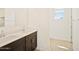 Bright bathroom with dual sinks, dark wood cabinetry and large mirror at 4182 W Lisa Ln, San Tan Valley, AZ 85144