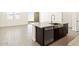 Kitchen island with stone countertop, dark wood cabinets and stainless steel dishwasher at 4182 W Lisa Ln, San Tan Valley, AZ 85144
