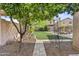 Lush backyard featuring artificial grass, a seating area, and mature trees that offers privacy at 4712 E Amberwood Dr, Phoenix, AZ 85048