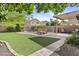 A well-maintained backyard features a covered patio and artificial turf, offering space for entertainment at 4712 E Amberwood Dr, Phoenix, AZ 85048