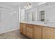 Bright bathroom featuring a dual sink vanity, large mirror, and clear glass shower with built in seating at 4712 E Amberwood Dr, Phoenix, AZ 85048