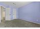 A cozy bedroom with neutral carpet with closet and ensuite bathroom access at 4712 E Amberwood Dr, Phoenix, AZ 85048