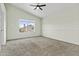 Inviting bedroom features a ceiling fan, neutral walls, and a window overlooking the front yard at 4712 E Amberwood Dr, Phoenix, AZ 85048