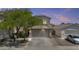Beautiful home at dusk featuring a spacious garage, mature landscaping and a colorful sky at 4712 E Amberwood Dr, Phoenix, AZ 85048