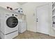 Well-equipped laundry room featuring modern washer and dryer, white shelving, and a tiled floor at 4712 E Amberwood Dr, Phoenix, AZ 85048