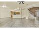 Open concept living area featuring tile flooring, staircase, and a view into the modern kitchen at 4712 E Amberwood Dr, Phoenix, AZ 85048