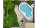 Aerial view of a backyard oasis featuring a freeform pool, lush greenery, and a cozy seating area at 4712 E Amberwood Dr, Phoenix, AZ 85048