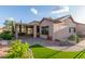 Well-maintained backyard with covered patio, artificial grass, and desert landscaping at 5381 S Emerald Desert Dr, Gold Canyon, AZ 85118