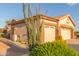 A well-maintained three-car garage featuring neutral-toned doors and desert landscaping in front at 5381 S Emerald Desert Dr, Gold Canyon, AZ 85118