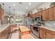 Well-appointed kitchen with wood cabinets, granite countertops, stainless steel appliances, and an island at 5381 S Emerald Desert Dr, Gold Canyon, AZ 85118