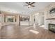 Spacious living room with wood floors, open to the kitchen and dining areas, featuring a stone fireplace at 5381 S Emerald Desert Dr, Gold Canyon, AZ 85118