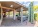 Covered outdoor patio area featuring pavers, lush desert landscaping, and a hot tub at 5381 S Emerald Desert Dr, Gold Canyon, AZ 85118