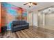 Open living room features modern decor, stylish graffiti brick wall, and wood-look floors at 5408 W Allen St, Laveen, AZ 85339