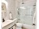 Bright bathroom featuring a white vanity, tiled walls, and a glass-enclosed shower/tub at 8863 S Grandview Dr, Tempe, AZ 85284