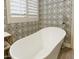 Standalone tub with white patterned wallpaper in the main bathroom at 8863 S Grandview Dr, Tempe, AZ 85284