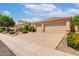 Inviting exterior view of a home showcasing desert landscaping, a tile roof, and a spacious three-car garage at 9154 E Caribbean Ln, Scottsdale, AZ 85260