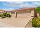 Spacious three-car garage featuring tan doors, accompanied by well-manicured landscaping and a tile roof at 9154 E Caribbean Ln, Scottsdale, AZ 85260