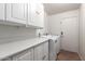 Bright laundry room with white appliances and cabinets at 9154 E Caribbean Ln, Scottsdale, AZ 85260